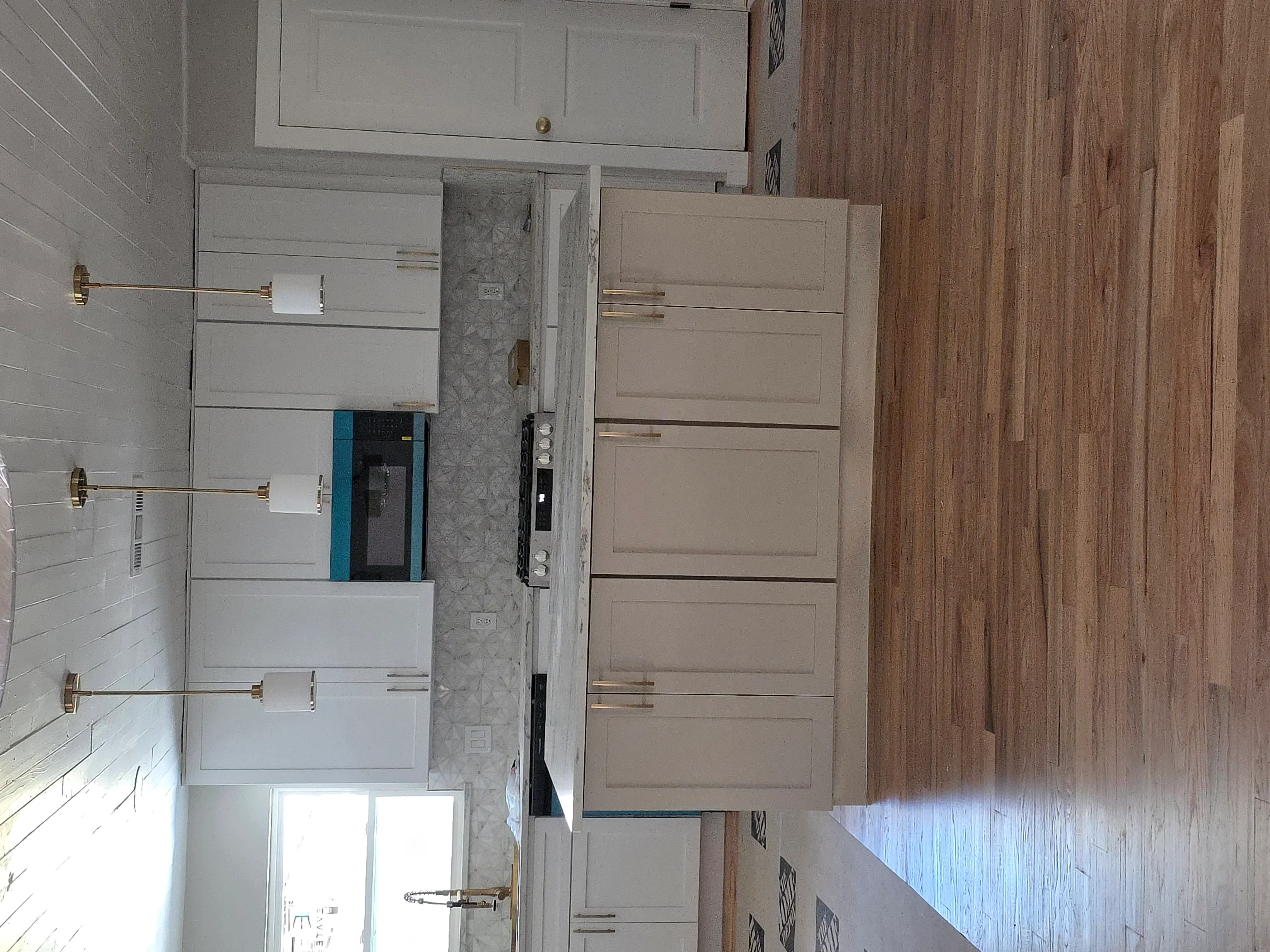 Kitchen electrical rough-in with white outlets, brass hardware, and wiring installation on shiplap walls