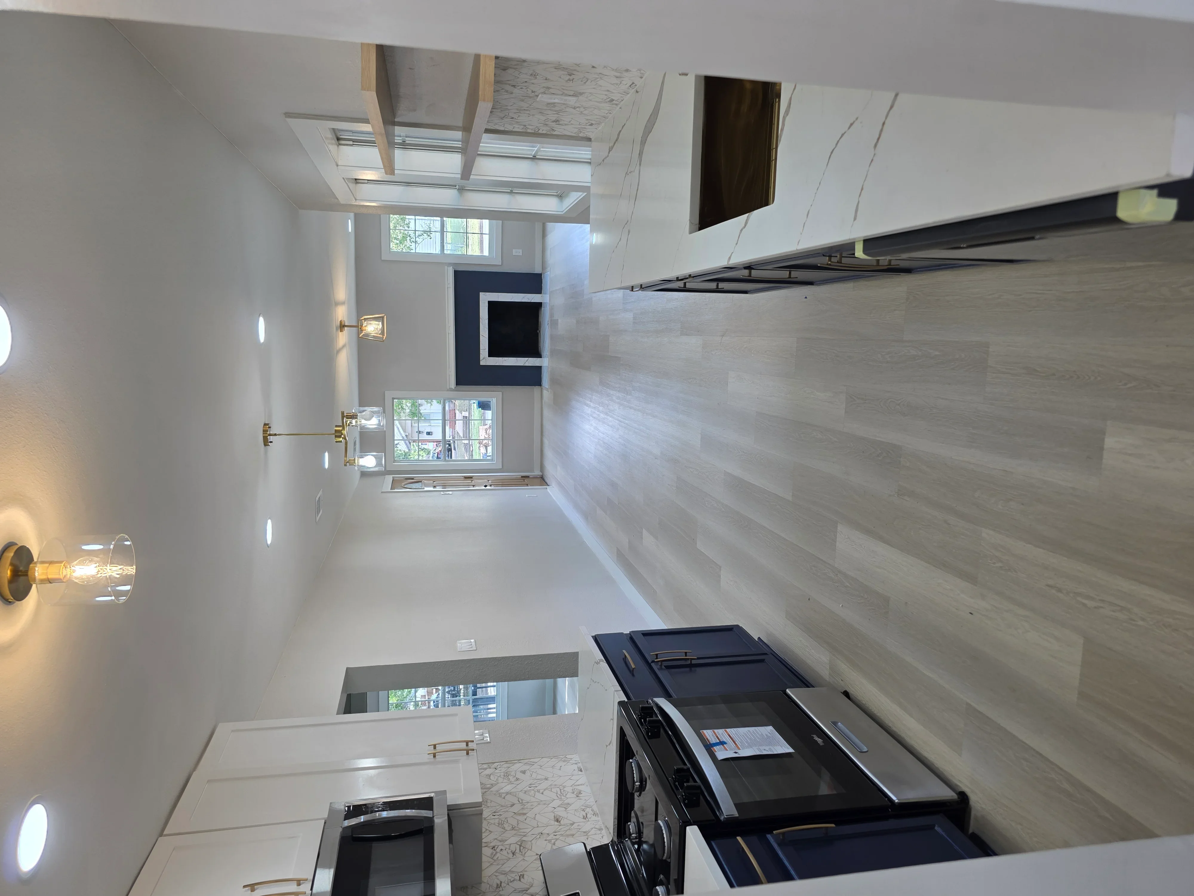 Kitchen with recessed lighting, skylight, under-cabinet lighting, and black range hood installation