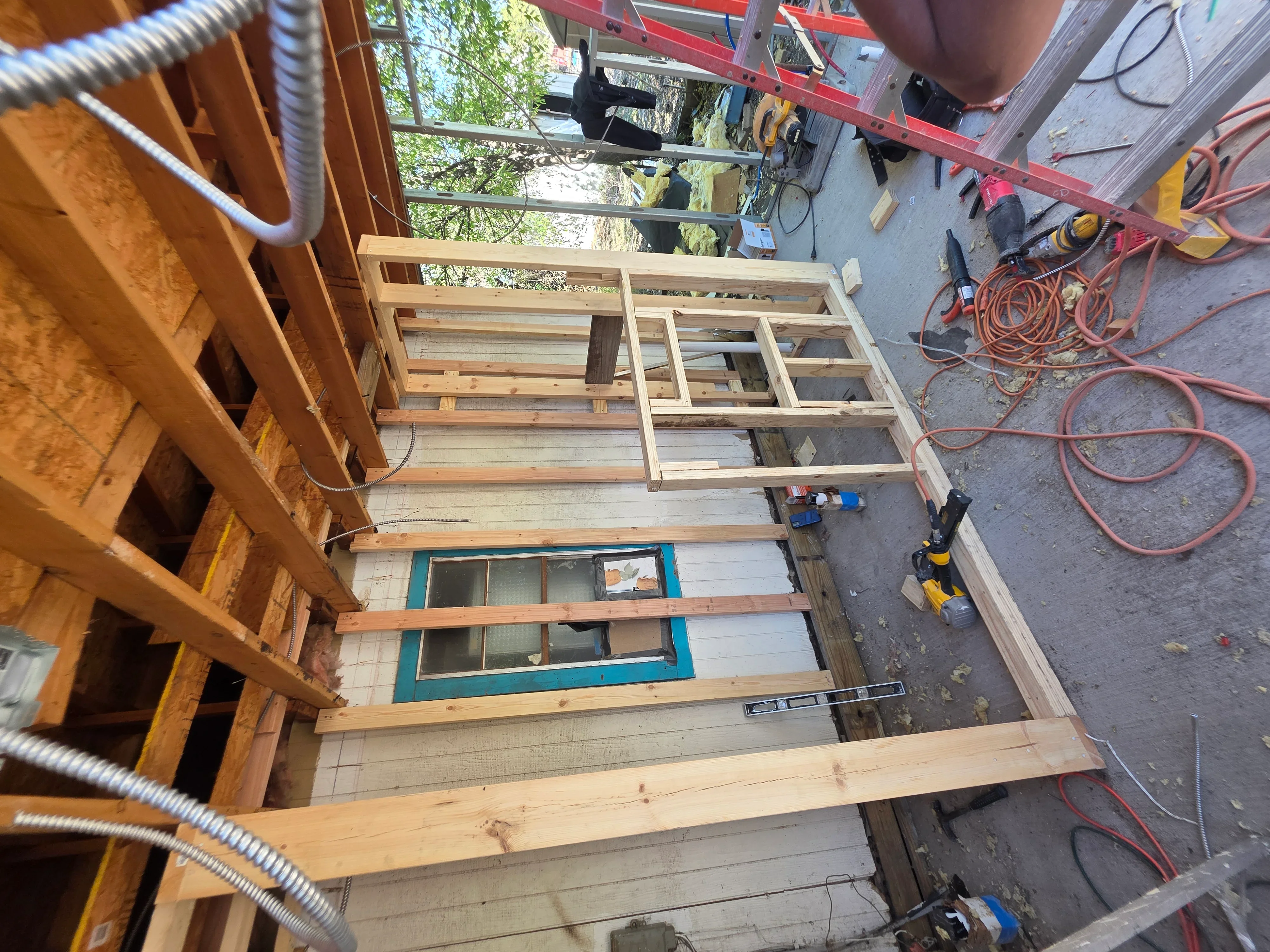 Pressure-treated deck framing with electrical conduit and wiring installation in progress