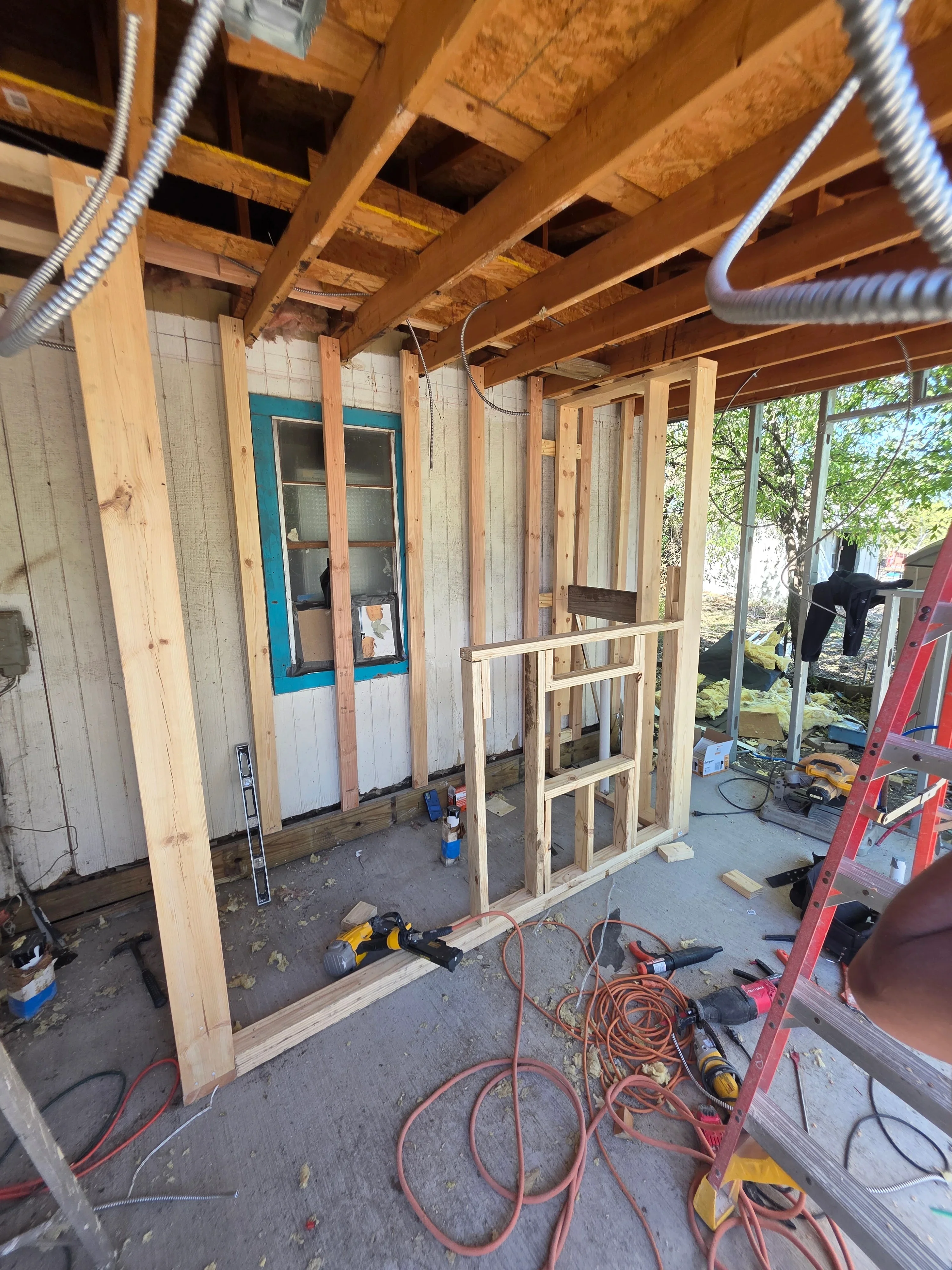 Electrical rough-in with flexible conduit and wiring installed in framed interior walls and ceiling joists