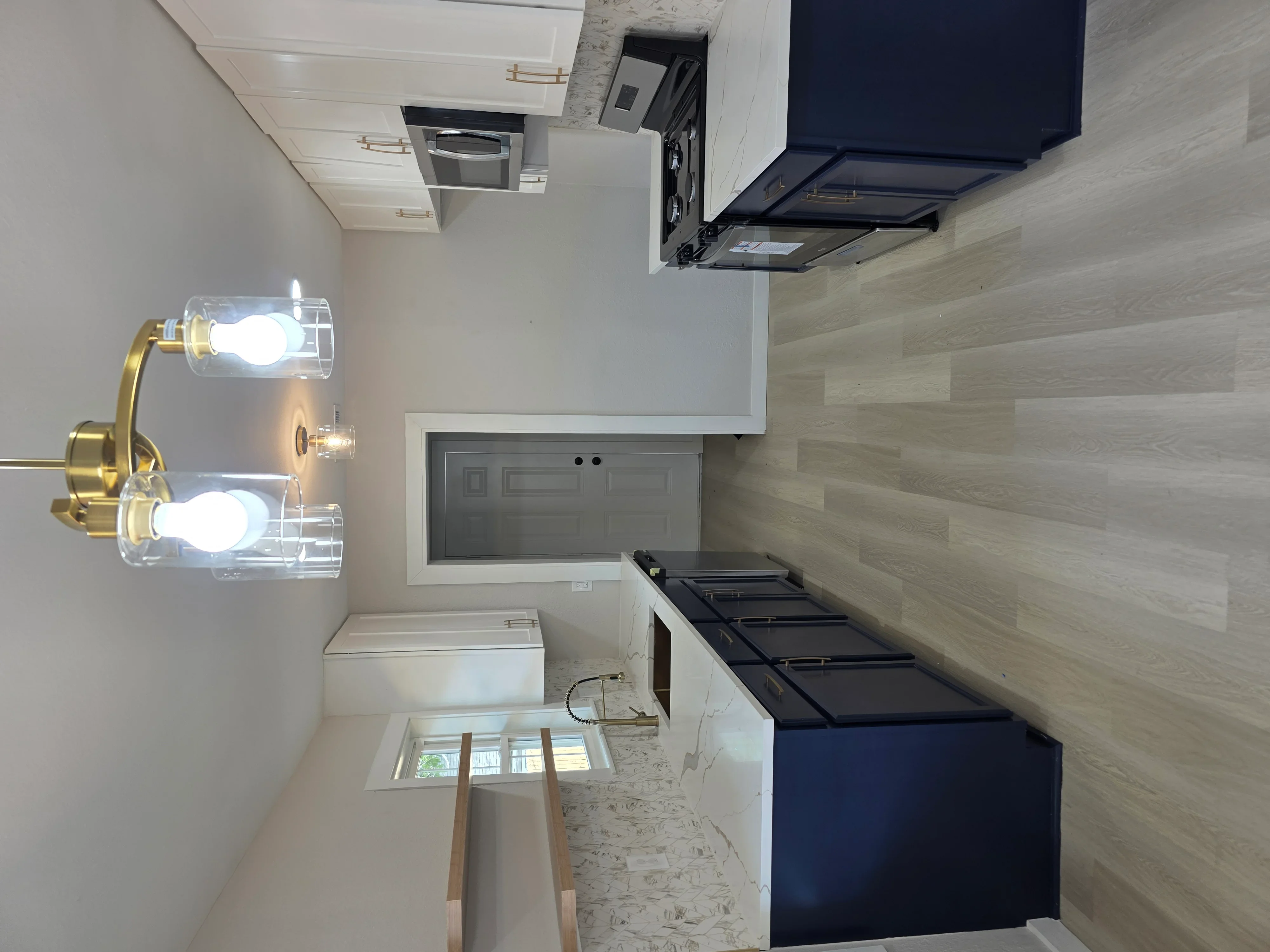 Kitchen electrical work with recessed lights, range hood wiring, and brass vanity sconces installed