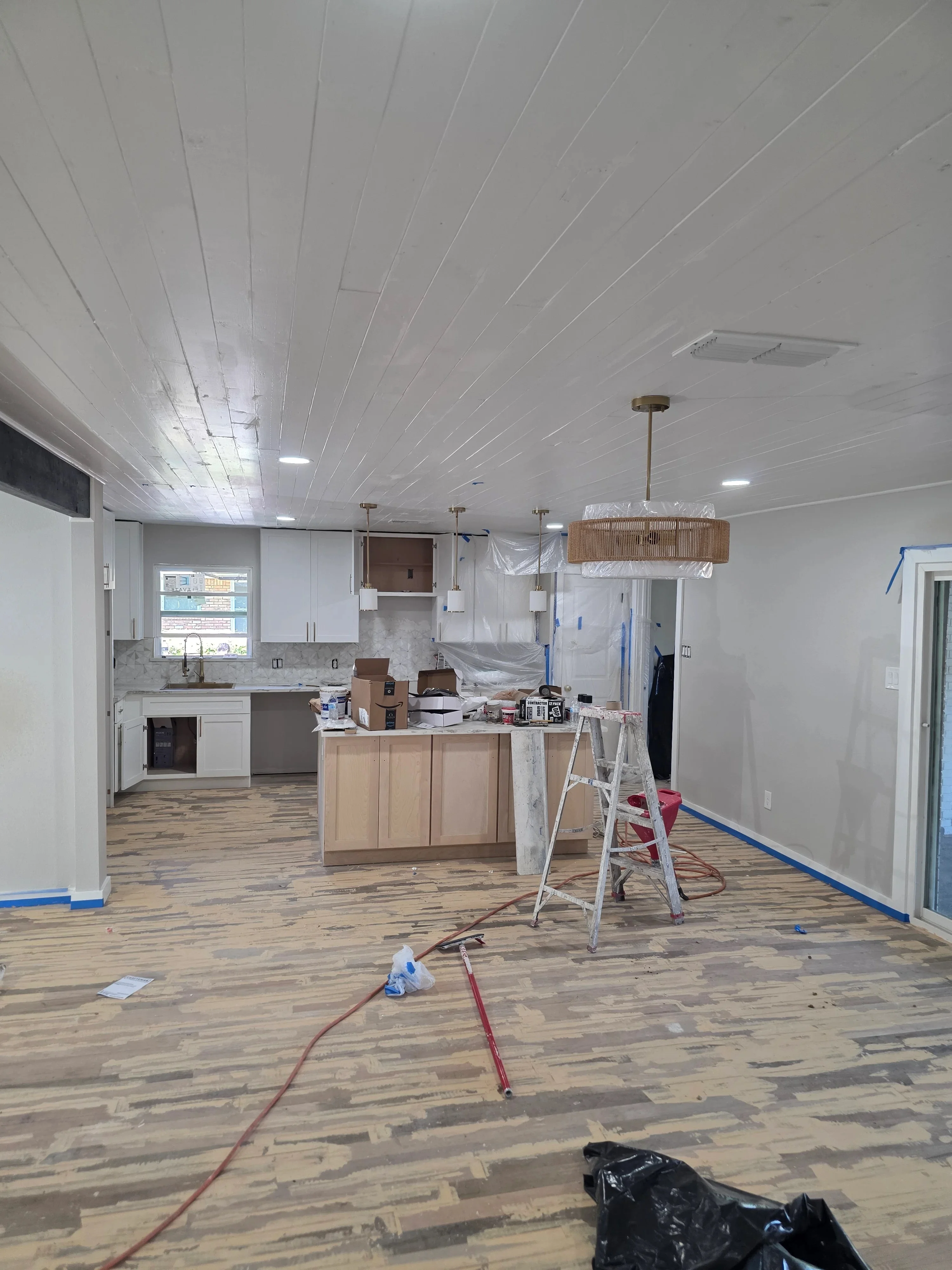 Kitchen renovation with new recessed ceiling lights, pendant fixtures, and electrical outlets during construction
