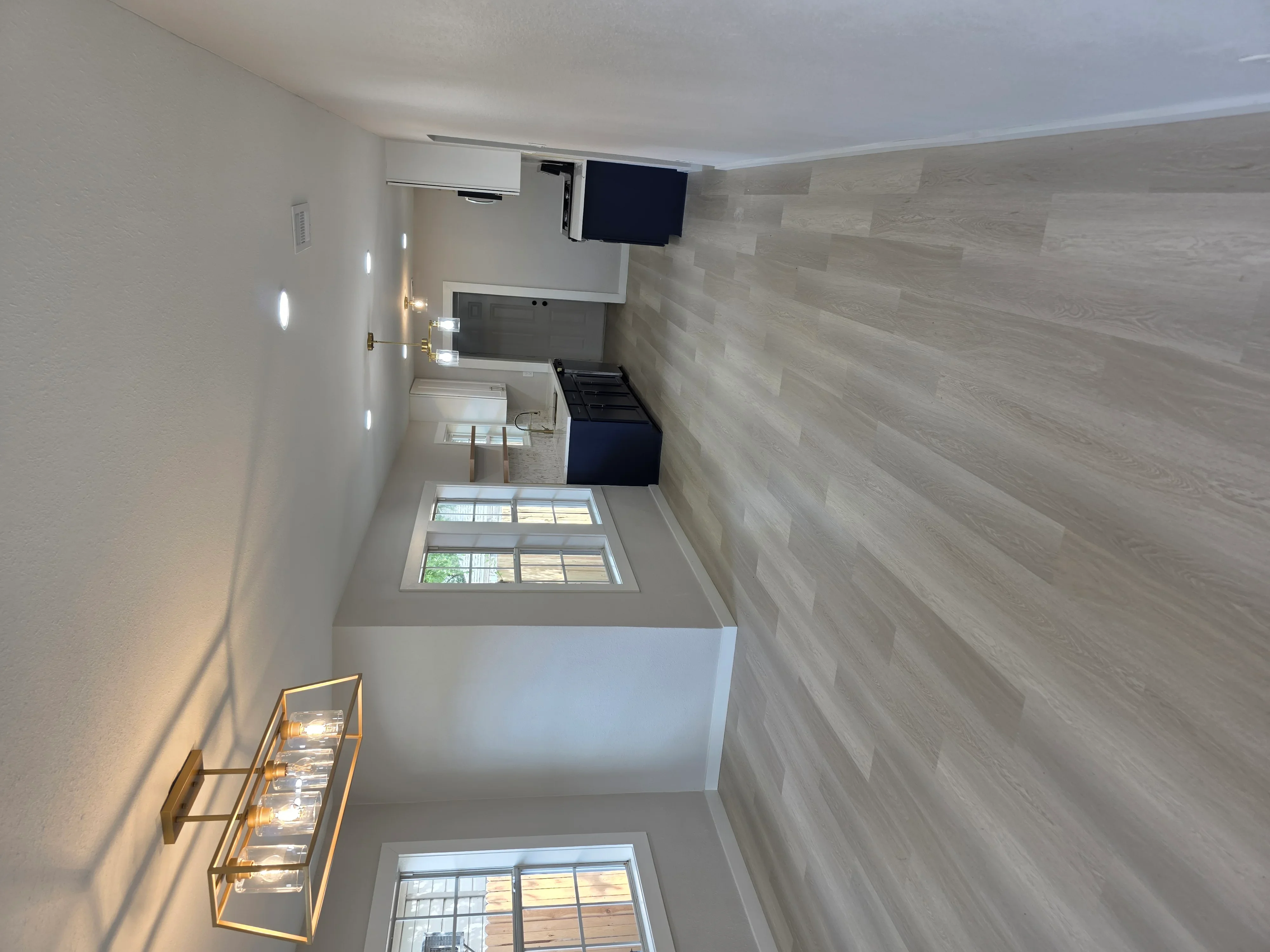 Recessed lighting, TV mount wiring, and electrical outlets in renovated bedroom with wood-look tile walls
